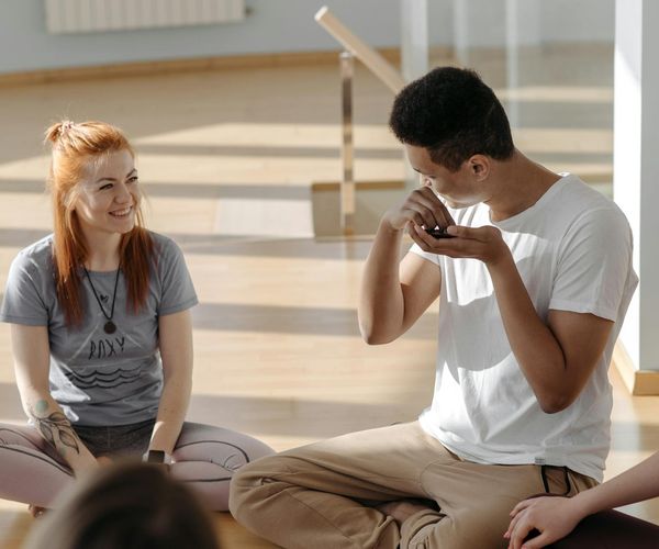 A diverse group of people sitting comfortably on yoga mats