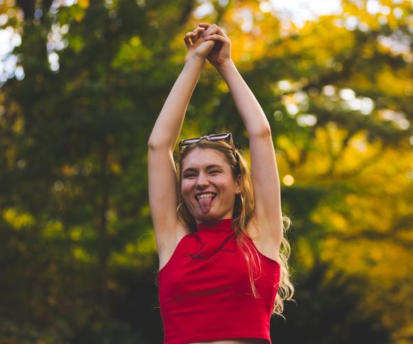 Woman smiling peacefully during a light stretching exercise outdoors